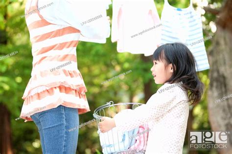 Girl Helping Mother Drying Laundry Smiling Stock Photo Picture And