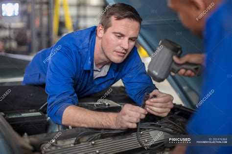 Car Mechanics Inspecting Car Engine In Repair Garage — Waist Up 35 To