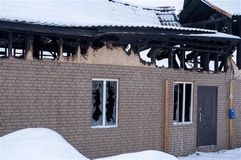 View Of A Wooden Village House After A Fire With A Burnt Roof And