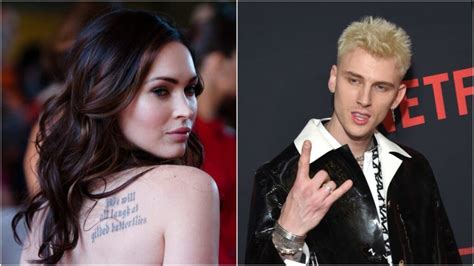 Mgk wears a bright red outfit, carrying the all black megan in his arms. I Hope Machine Gun Kelly Isn't Really Dumb Enough to Date Megan Fox
