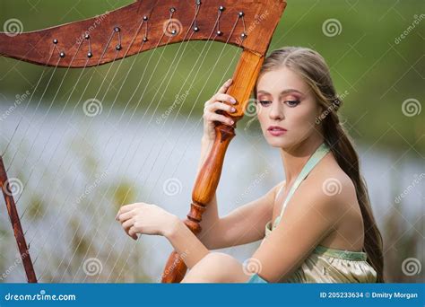 Pretty Harpist Playing Her Harp Stock Photography