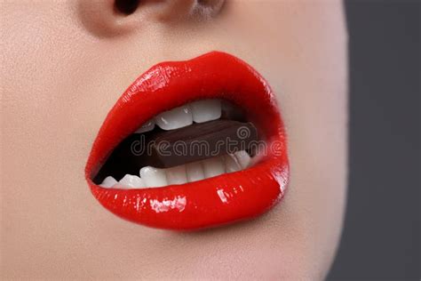 Young Woman With Beautiful Lips Eating Chocolate On Grey Background