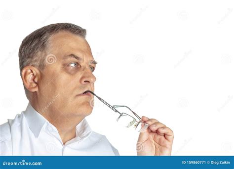 The Man Is Thoughtful And Holds Glasses In His Mouth On A White