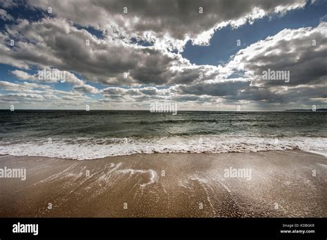 View Of The Sea Surf Under The Contrasting Blue Cloudy Sky Stock Photo