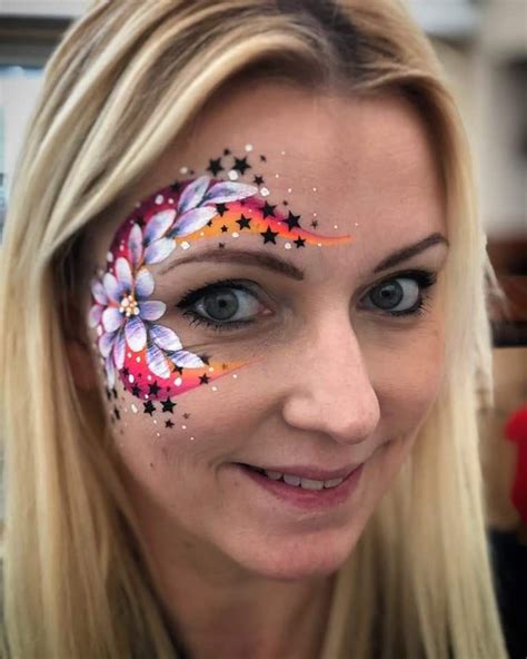 A Woman With Her Face Painted Like A Butterfly And Stars On Its Forehead