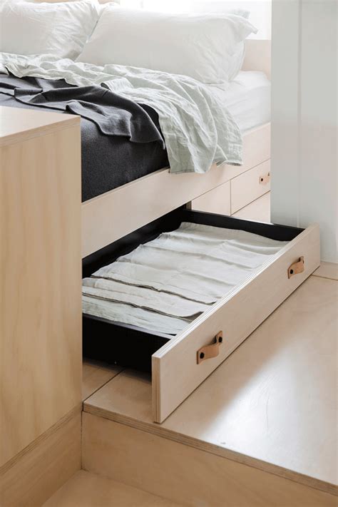 A Bed With Drawers Underneath It In A Bedroom