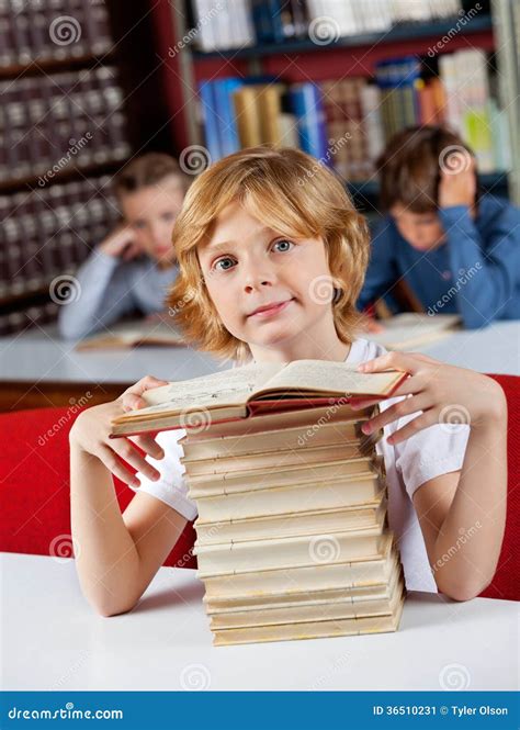 Schoolboy Sitting With Stack Of Books At Table In Stock Image Image