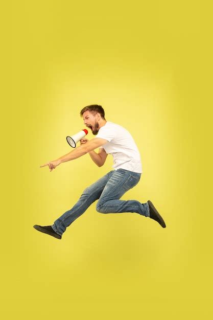 free photo full length portrait of happy jumping man isolated on yellow background caucasian