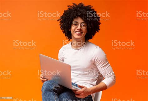 Black Millennial Man Sitting On Chair And Working On Laptop Online