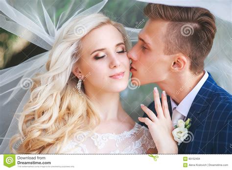 Wedding Bride And Groom Kissing At A Beautiful Park On