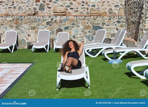 Beautiful Brunette Woman Dressed In Black Summer Suit Relaxing On Sun Lounger Sunbathing By The