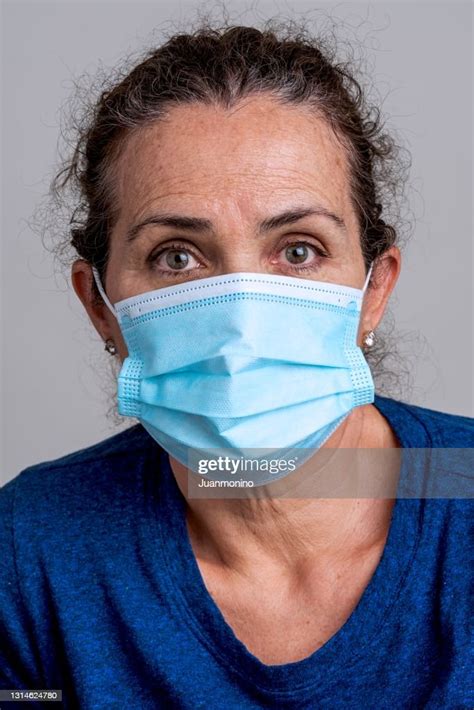 Pensive Mature Caucasian American Woman Wearing A Protective Face Mask Looking At The Camera