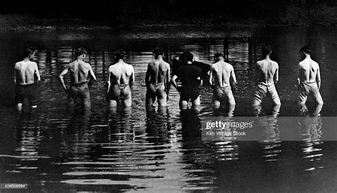 Rear View Of A Line Of Young Men Urinating In A River Together Photo D