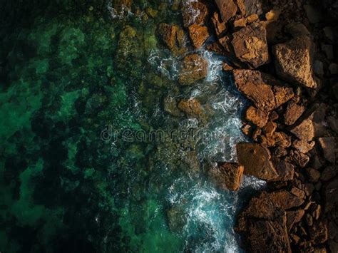 Aerial Top View Of Sea Waves Hitting Rocks On The Beach With Turquoise