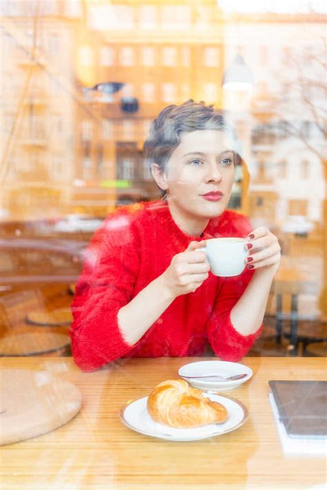 Mid Adult Woman In Cafe Drinking Coffee Looking Out Window View Stock