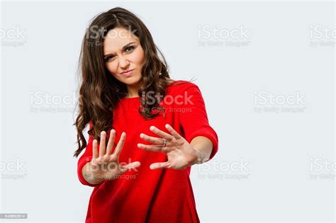 Angry Young Woman Put Her Hands Up In Studio Stock Photo Download