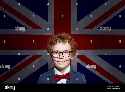 Happy Cute Kid Boy In Glasses With The Uk Flag Background English