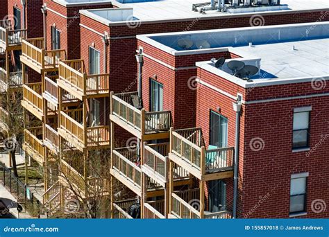 Wooden Balconies On The Side Of Brick Urban Residential Buildings In