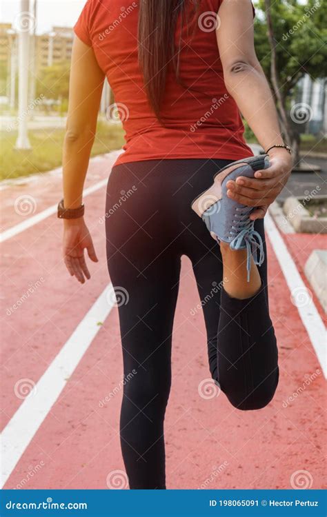 Woman Stretching Her Legs Before Running On The Track Healthy