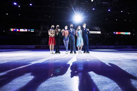 Five People Standing On An Ice Rink At Night