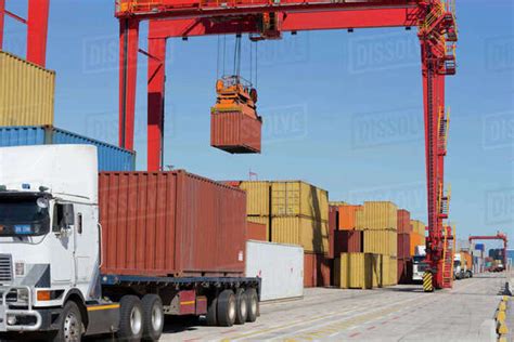 Crane Lifting Cargo Container At Commercial Dock Stock Photo Dissolve