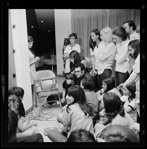 Group Of Women And A Man Gathered Around A Tv Most Likely Broadcasting