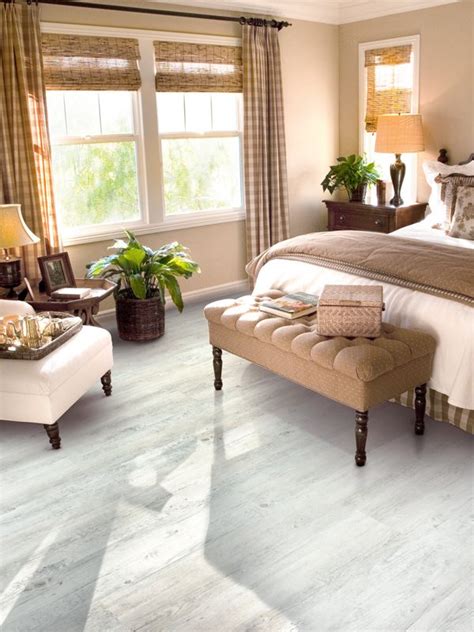 Relaxed neutral bedroom with dark wooden floors, wooden furniture and light natural bedding. White wood-effect vinyl flooring brings a quaint chic to ...