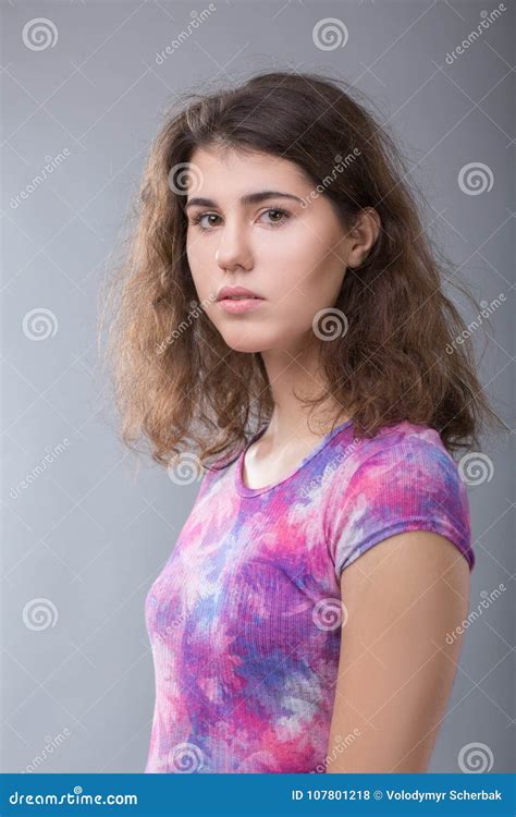 Portrait Of An Ordinary Young Woman On Gray Background Stock Photo