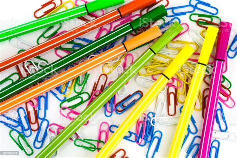 Multicolored Paper Clips And Markers Randomly Scattered On White Paper