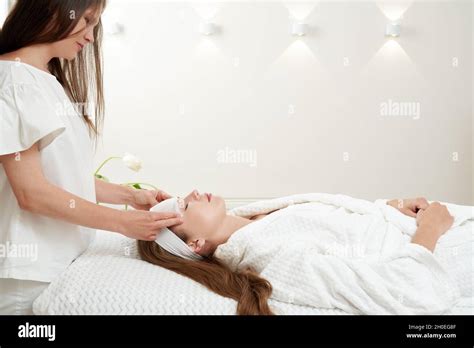 Cosmetologist Applying Rejuvenating Facial Mask On A Female Face In Beauty Salon Facial