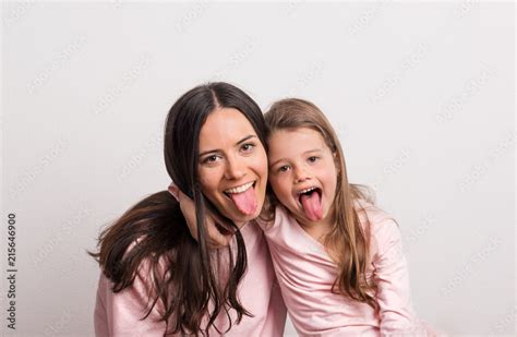 A Small Girl And Her Mother Sticking Tongues Out In A Studio Stock Photo Adobe Stock