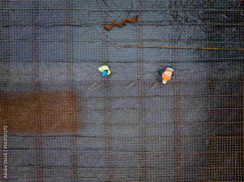 Construction As Art A Perpendicular Aerial View Of A Reinforcing Steel Mesh And Two Workers