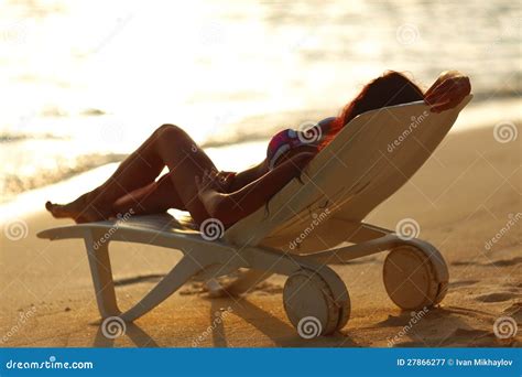 Woman In Chaise Lounge Relaxing On Beach Royalty Free Stock Photography