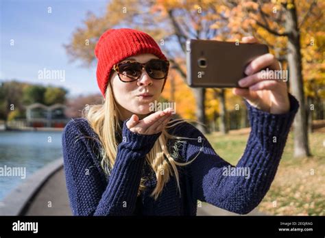 Canadian Woman In Park Using Smartphone To Take Selfie With Blowing A
