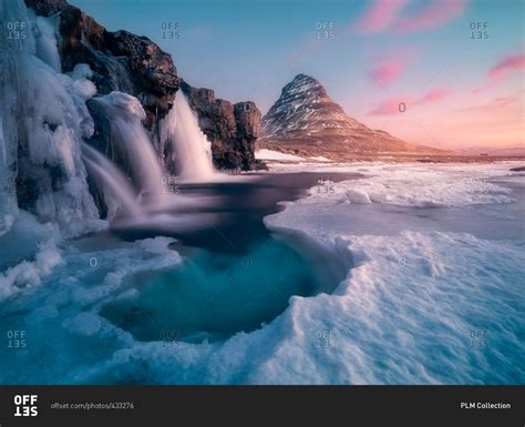 Kirkjufell Mountain With Icy Waterfalls In The Winter At Sunrise