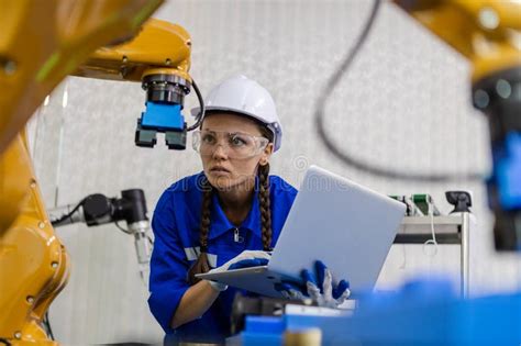 Female Technician Engineer Using Laptop Checking Automation Robotics At