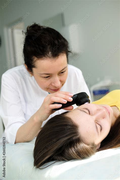 Female Dermatologist Using A Professional Dermatoscope While Doing Skin