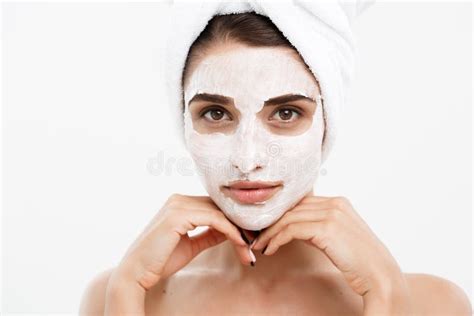 beauty skin care concept beautiful caucasian woman face portrait applying cream mask on her