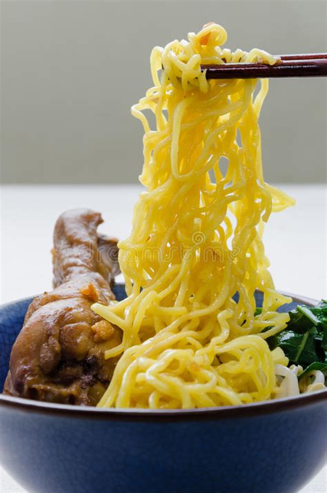 In a short time your hand will gain dexterity. Chopsticks Hold Egg Noodle Stewed Chicken From Bowl. Stock Photo - Image of yellow, chopsticks ...