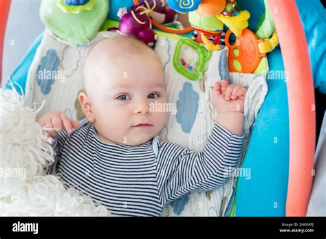 Portrait Of A Baby Boy Lying Down On A Playmat With Soft Toys Around