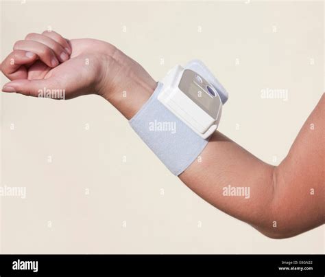 Forearm Of A Woman With An Attached Blood Pressure Monitor Stock Photo