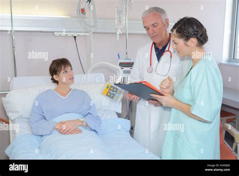 Doctor And Nurse Talking To Patient In Hospital Bed Stock Photo Alamy
