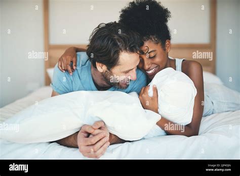 Fun Interracial Couple Laughing Bonding And Lying On Bed In A Home