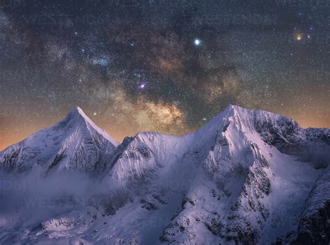 Amazing View Of White Snowy Mountain Range Under Incredible Night Starry Sky With Breaking Rays
