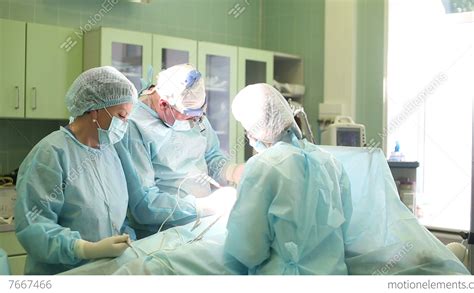 Surgeon Performing Cosmetic Surgery On Breasts In Hospital Operating