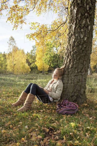 Girl Sitting Under Tree In Park Stock Photo Dissolve