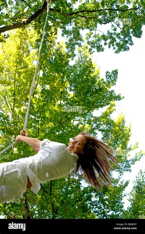 Woman Swinging On Rope And Smiling Stock Photo Alamy