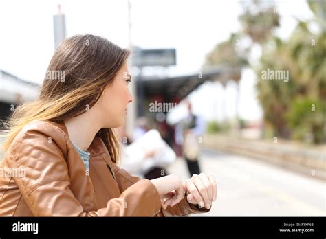 Angry Girl Waiting In A Train Station And Looking To Railway Stock