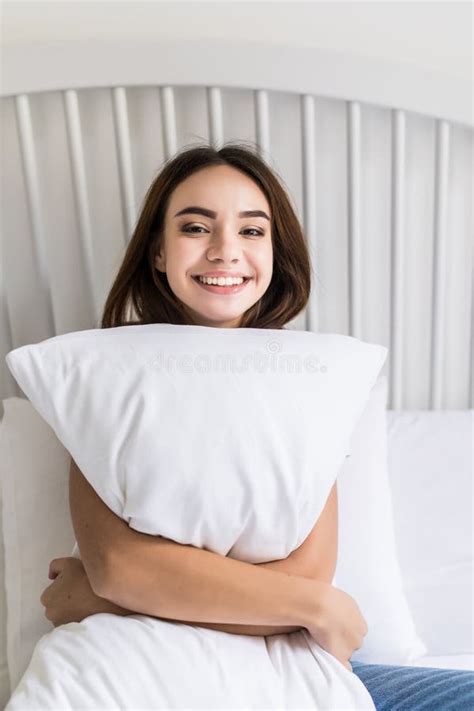Sensual Smiling Young Woman Sitting On Bed And Hugging White Pillow