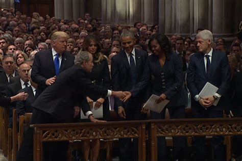 video shows george w bush appearing to slip candy to michelle obama at funeral for george hw